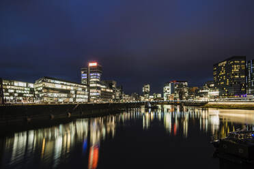 Germany, North Rhine-Westphalia, Dusseldorf, Illuminated waterfront of Medienhafen at night - CHPF00816