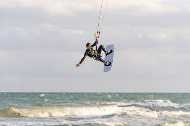 Mann beim Kiteboarden über dem Meer im Urlaub - DLTSF02453