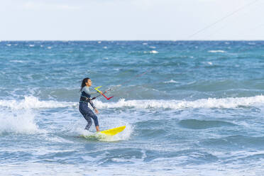 Frau beim Kiteboarden auf dem Wasser - DLTSF02458