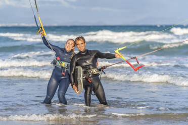 Lächelnde Freunde beim Kitesurfen im Wasser - DLTSF02462