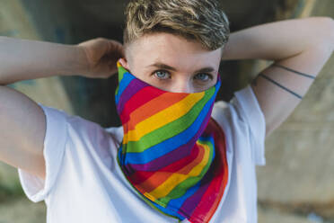 Young woman covering face with multi colored bandana - MGIF01185