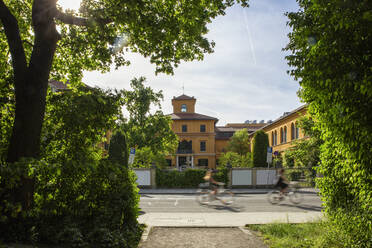 Deutschland, Bayern, München, Zwei Radfahrer passieren das Lenbachhaus Museum - MAMF01977