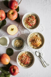 Studioaufnahme von Schalen mit frischem Porridge und Gala-Äpfeln - EVGF03940