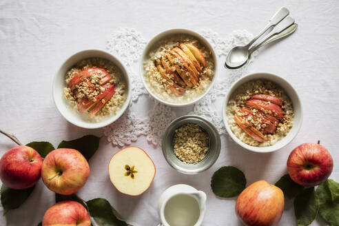 Studioaufnahme von Schalen mit frischem Porridge und Gala-Äpfeln - EVGF03944