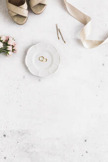 Studio shot of women's shoes, roses, ribbon and plate with pair of wedding rings - FLMF00715