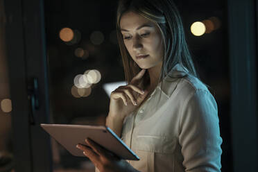 Nachdenkliche Geschäftsfrau mit digitalem Tablet im Büro - JSRF01755