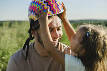 Daughter holding helmet on father's head - SEAF00191