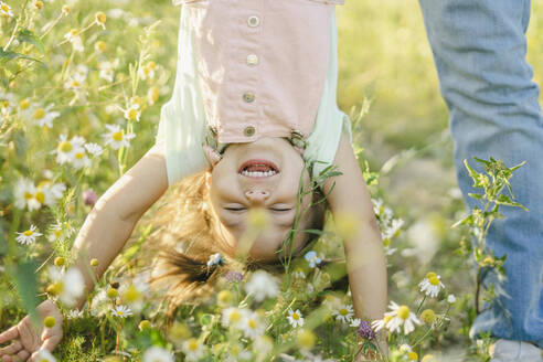 Carefree daughter playing with father by flowers - SEAF00201