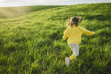 Carefree girl running on grass in meadow - SEAF00220