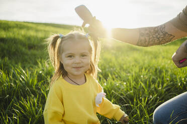 Smiling daughter with father holding comb on sunny day - SEAF00222