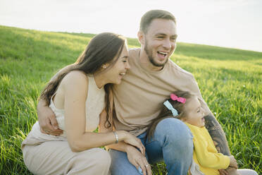 Playful couple enjoying with daughter on grass - SEAF00226