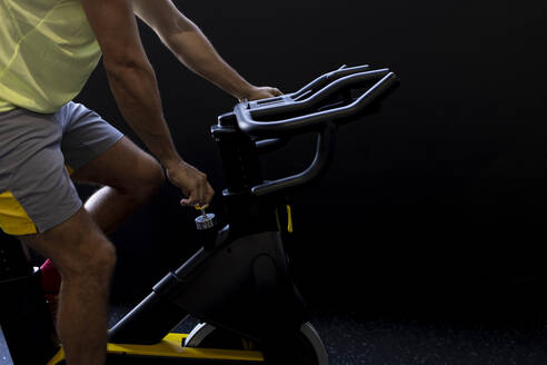 Sportsman cycling exercise bike at gym - JPTF00941