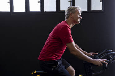 Sportler trainiert auf dem Fahrrad im Fitnessstudio - JPTF00943