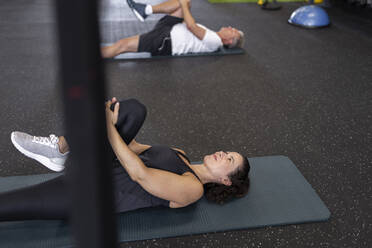 Sportlerin und Freundin machen Dehnungsübungen im Fitnessstudio - JPTF00971