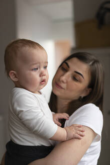 Mutter schaut auf trauriges Baby Tochter zu Hause - SSGF00345