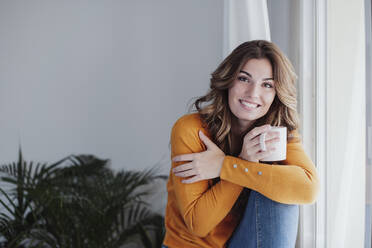 Beautiful woman with coffee cup at home - EBBF04973