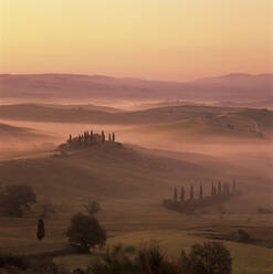 Toskanisches Bauernhaus mit Zypressen in nebliger Landschaft bei Sonnenaufgang, San Quirico d'Orcia, Provinz Siena, Toskana, Italien, Europa - RHPLF21073