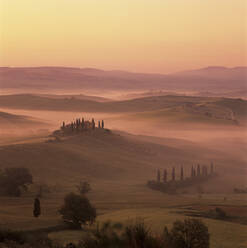 Tuscan farmhouse with cypress trees in misty landscape at sunrise, San Quirico d'Orcia, Siena Province, Tuscany, Italy, Europe - RHPLF21073