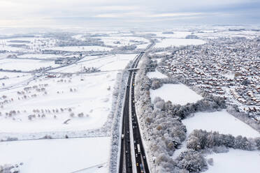 UK, England, Lichfield, Luftaufnahme einer mehrspurigen Autobahn, die sich am Rande einer schneebedeckten Stadt erstreckt - WPEF05557