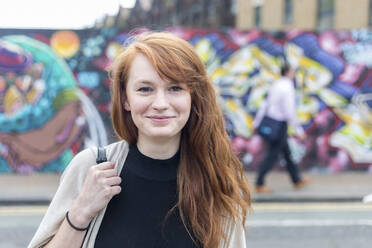 Young redhead woman smiling at street - WPEF05560