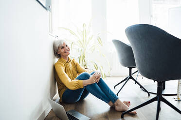 Ältere Geschäftsfrau sitzt mit Laptop auf dem Boden - JOSEF06019