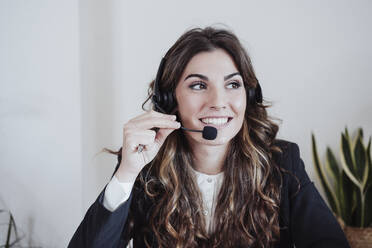 Customer service representative talking on headset at office - EBBF05045