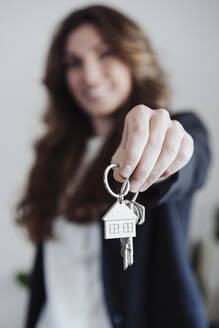 Immobilienmakler mit Hausschlüssel im Büro - EBBF05057