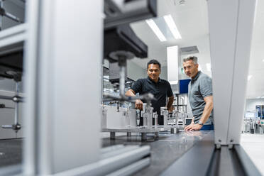 Two men examining machinery at industry - DIGF17024