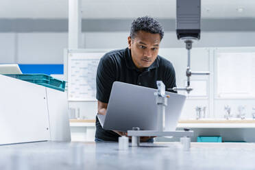 Ingenieur mit Laptop bei der Arbeit in einer Produktionsstätte - DIGF17037