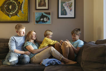 Family sitting on sofa at home - IHF00690