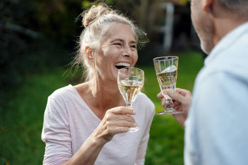 Lächelnde Frau trinkt Champagner mit Mann im Hinterhof - JOSEF06113