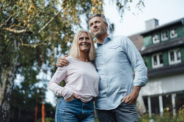 Couple with hands in pockets at backyard - JOSEF06146