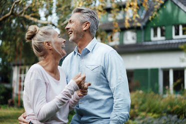 Cheerful couple standing at backyard - JOSEF06156