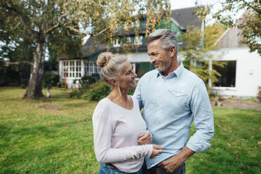 Smiling woman standing by man at backyard - JOSEF06195