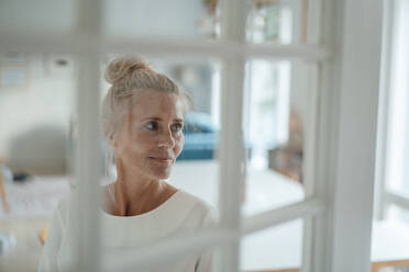 Frau schaut aus dem Fenster zu Hause - JOSEF06217