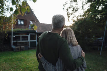 Couple standing with arms around at backyard - JOSEF06237