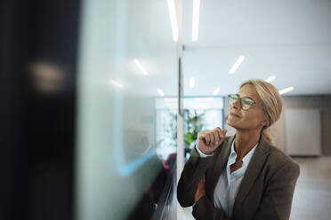 Geschäftsfrau mit Brille schaut auf einen Bildschirm im Büro - JOSEF06268