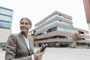 Lächelnde Geschäftsfrau mit Tablet-PC in der Stadt - JOSEF06299