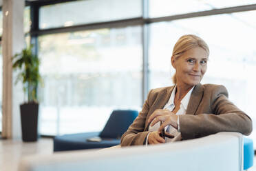 Blonde Geschäftsfrau auf dem Sofa in der Büro-Lobby - JOSEF06328