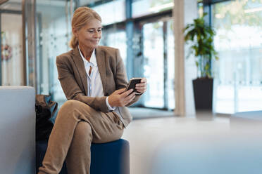 Geschäftsfrau benutzt Mobiltelefon im Büro - JOSEF06333