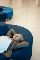 Geschäftsfrau mit Händen hinter dem Kopf entspannt in der Büro-Lobby - JOSEF06340