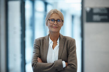 Confident businesswoman with arms crossed in office - JOSEF06355