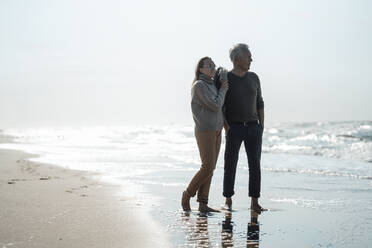 Tochter und Vater stehen zusammen am Meer an einem sonnigen Tag - GUSF06569