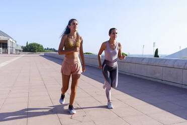 Daughter jogging with mother on sunny day - RFTF00143