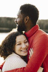 Smiling woman embracing boyfriend during weekend - MASF27218