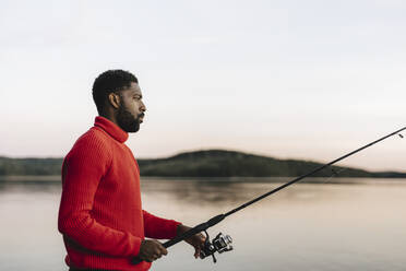 Free Photo, Side view of young man holding fishing rod