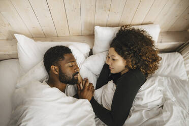 Directly above view of couple sleeping on bed in hotel - MASF27290