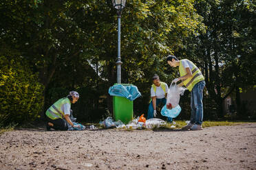 Männliche und weibliche Aktivisten sammeln Plastikmüll im Park auf - MASF27329