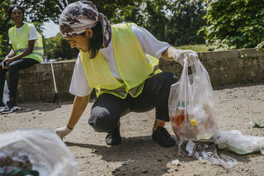 Junge Freiwillige sammelt Plastikmüll im Park auf - MASF27338