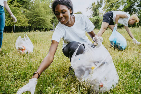 Umweltschützerinnen und Umweltschützer sammeln Plastikmüll im Park ein - MASF27345